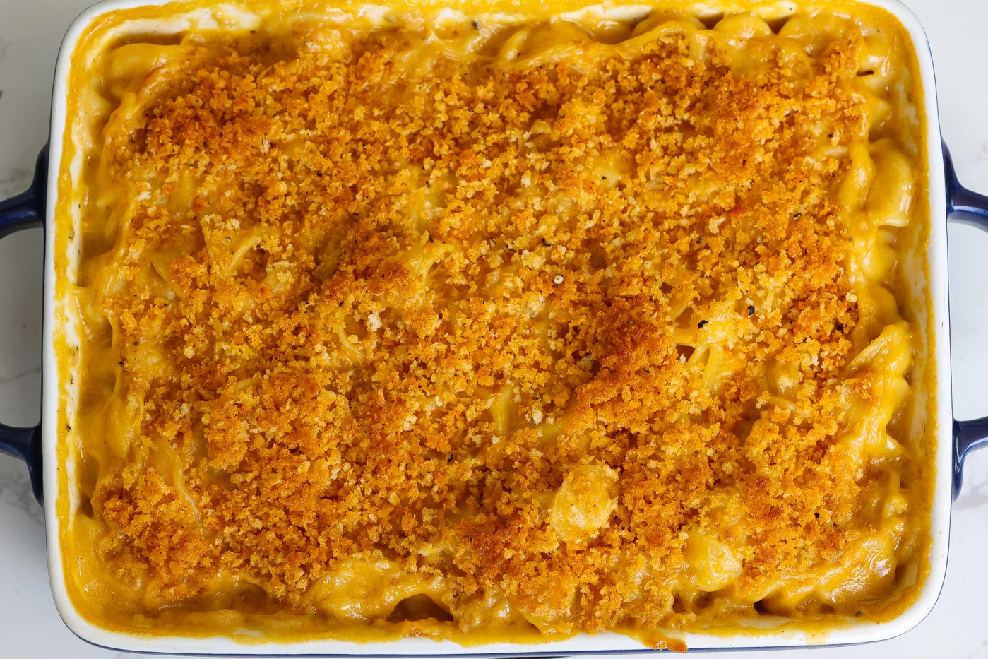 vegan mac and cheese with crunchy topping in a white baking dish