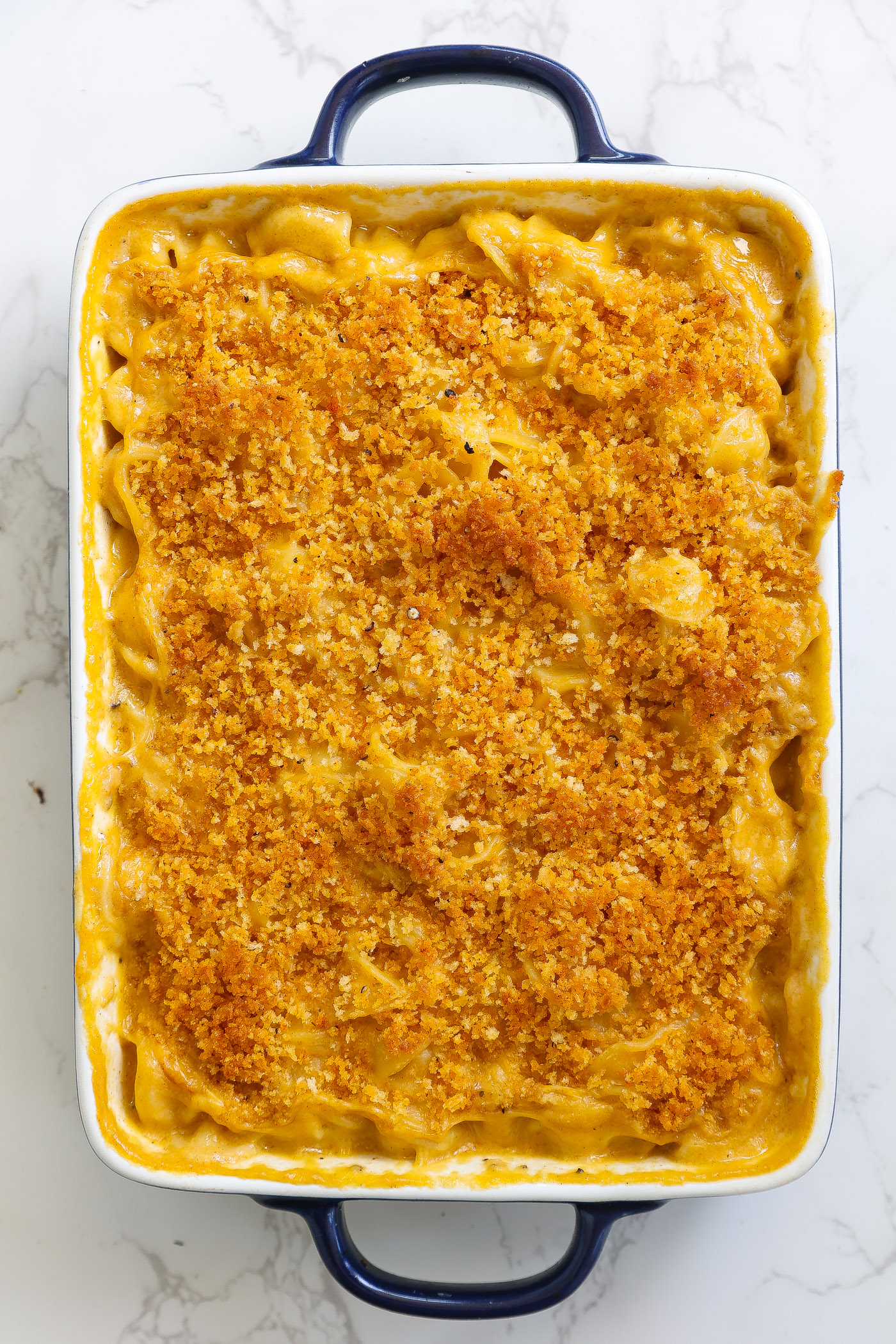 vegan mac and cheese with crunchy topping in a white baking dish