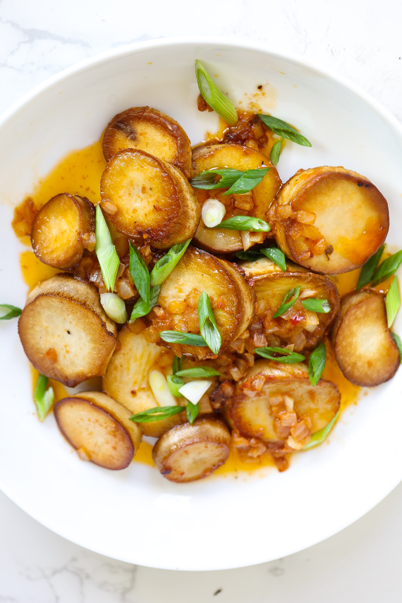 vegan mushroom scallops in white bowl topped with green onions