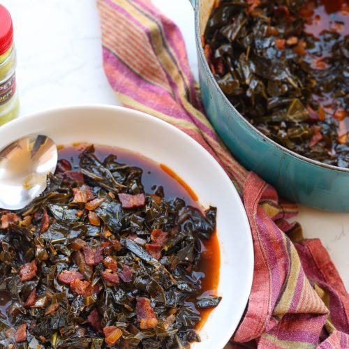 braised collard greens with bacon in a white bowl