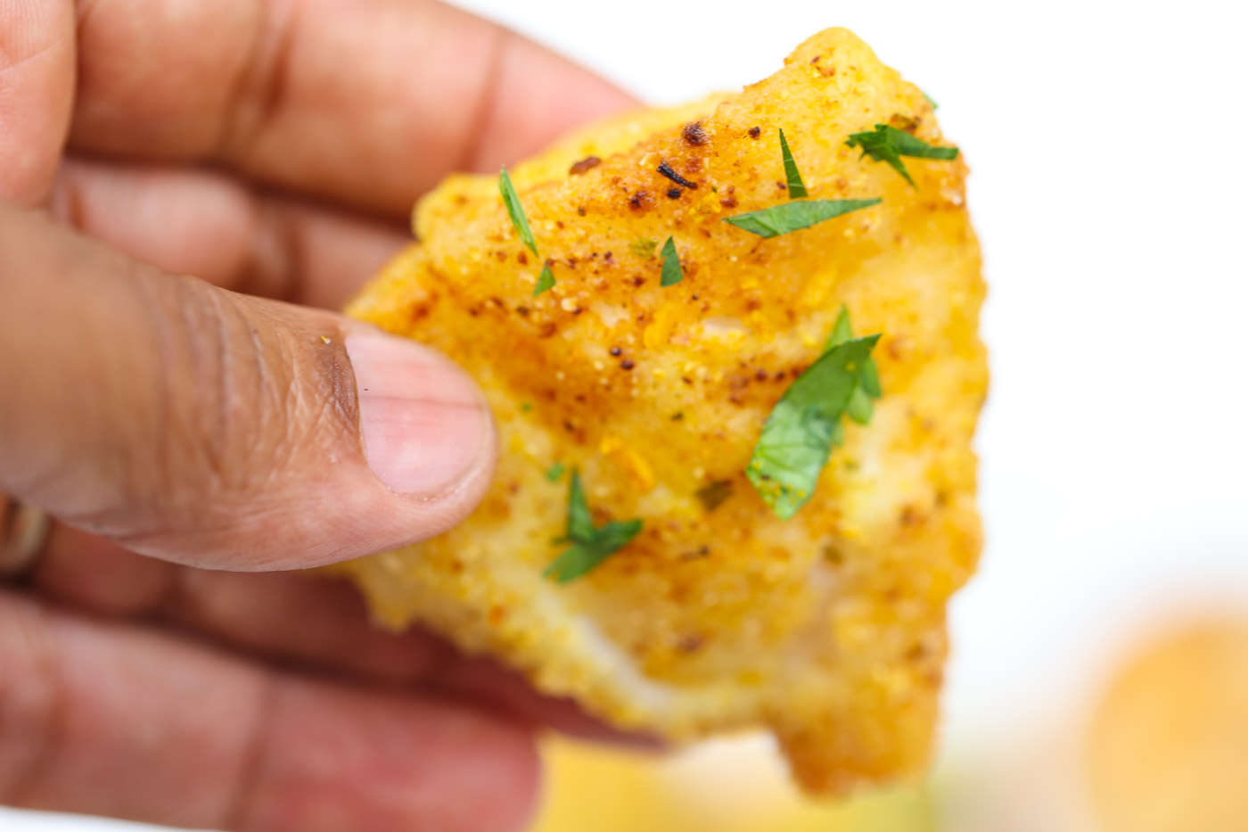 pan fried cod being held in hand