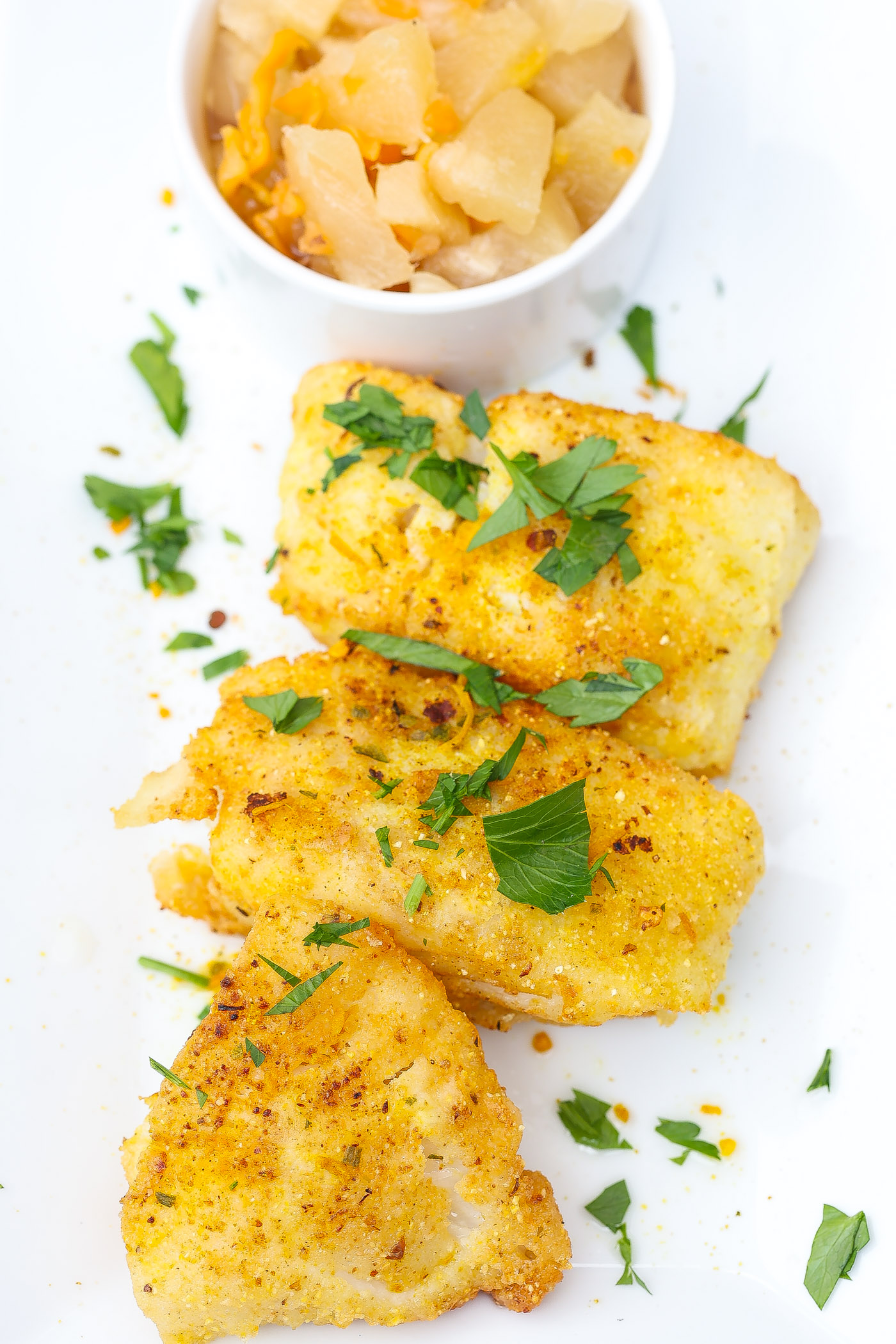 pan fried cod fillets on a white plate