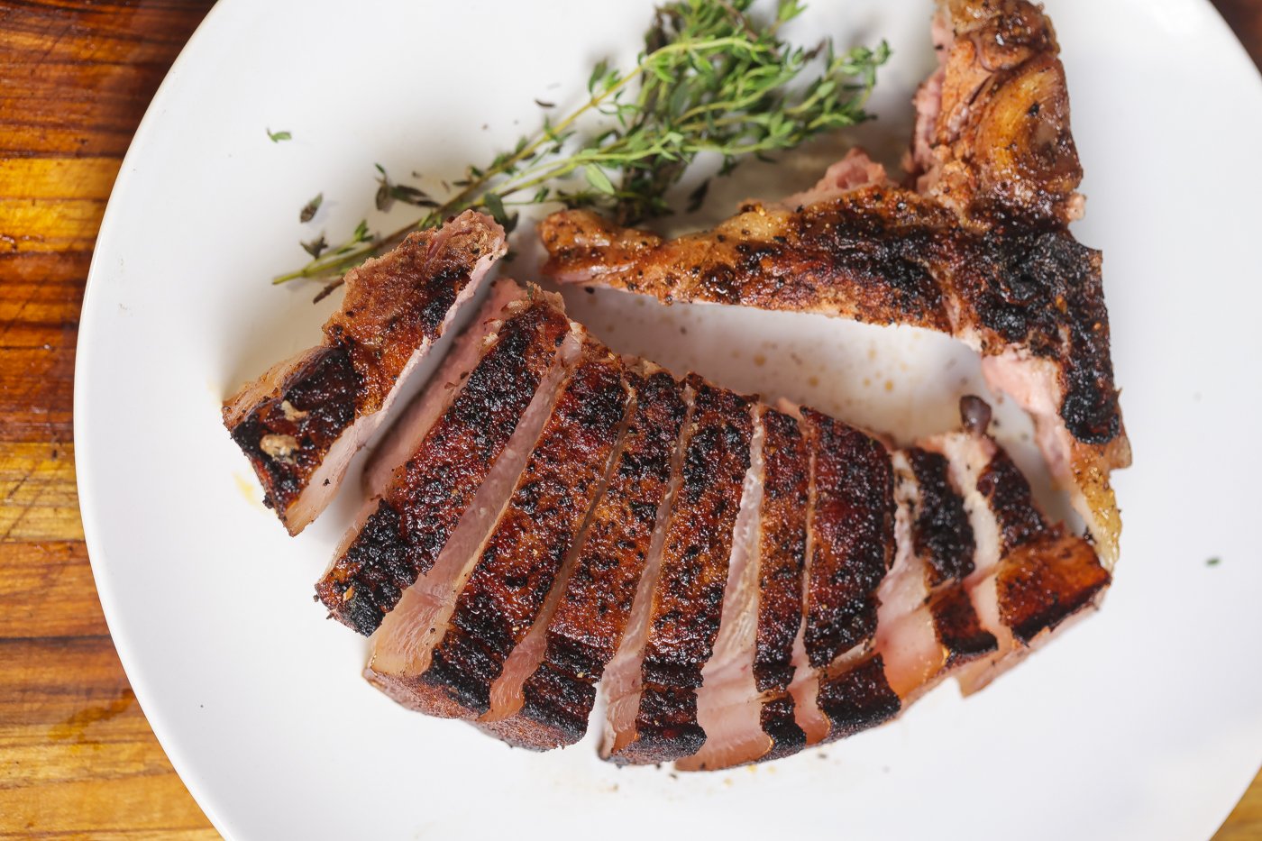 sliced reverse seared pork chop on white plate