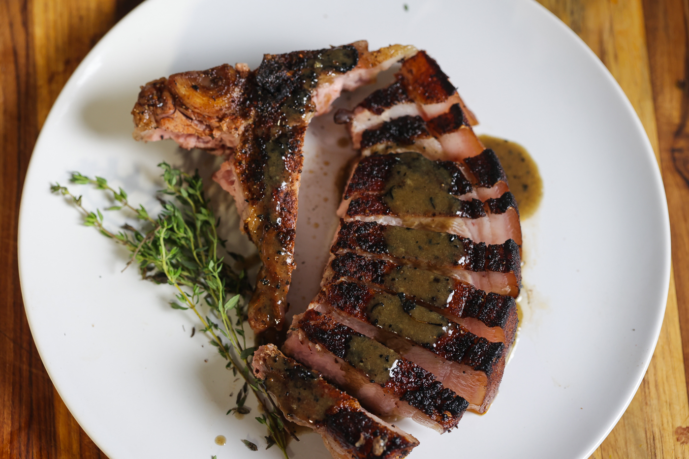 sliced reverse seared pork chop on white plate