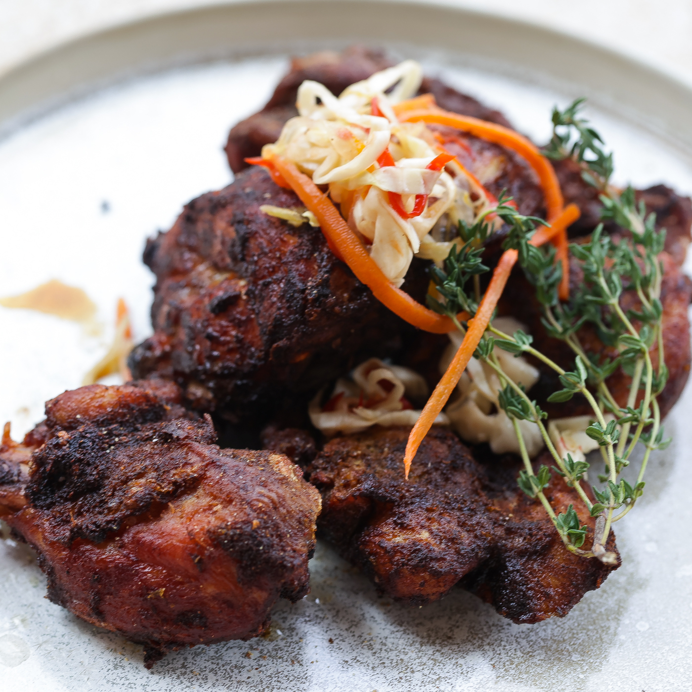 haitian fried chicken on a white plate topped with pickled slaw