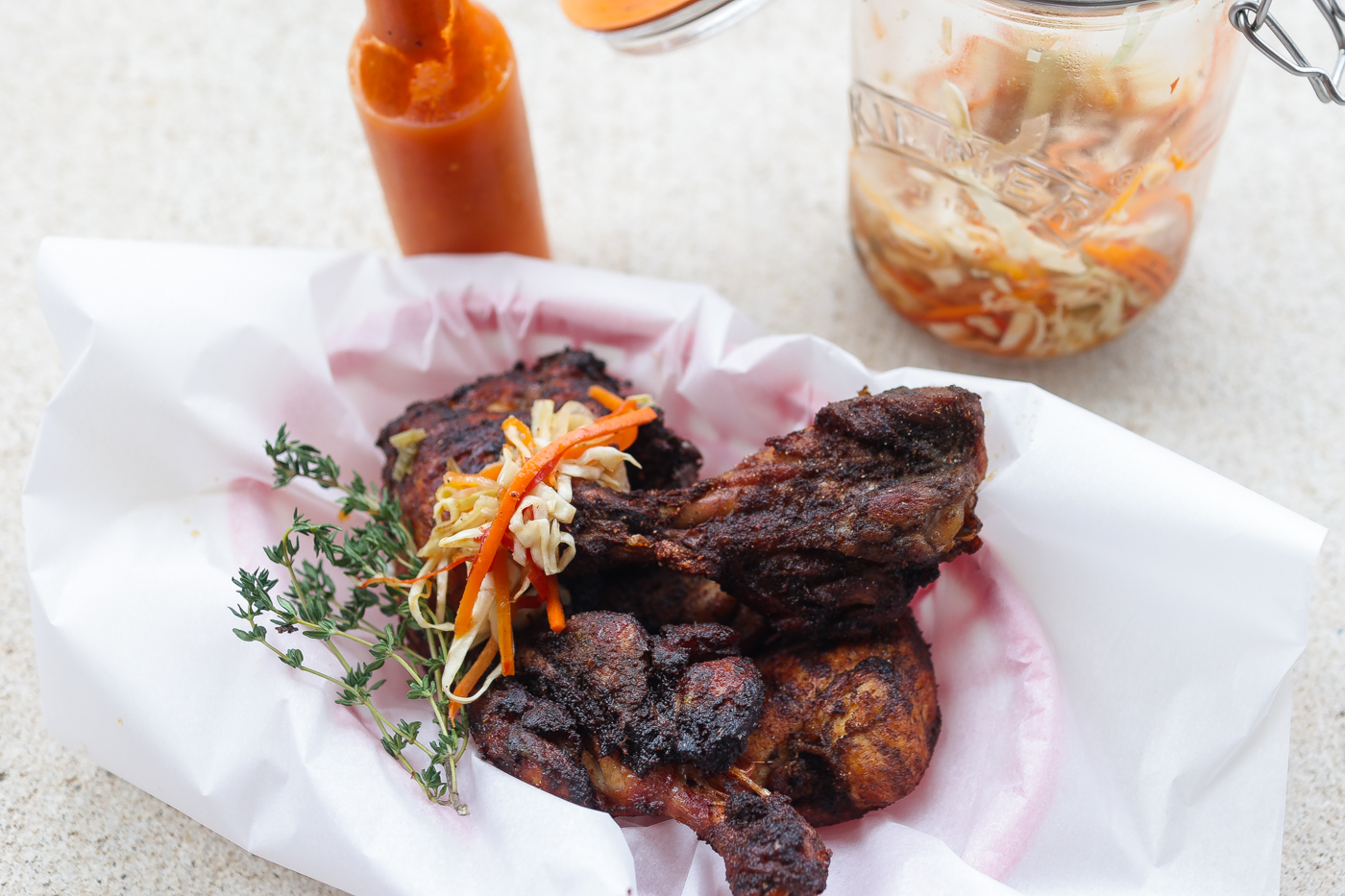 haitian fried chicken in a basket topped with pickled slaw