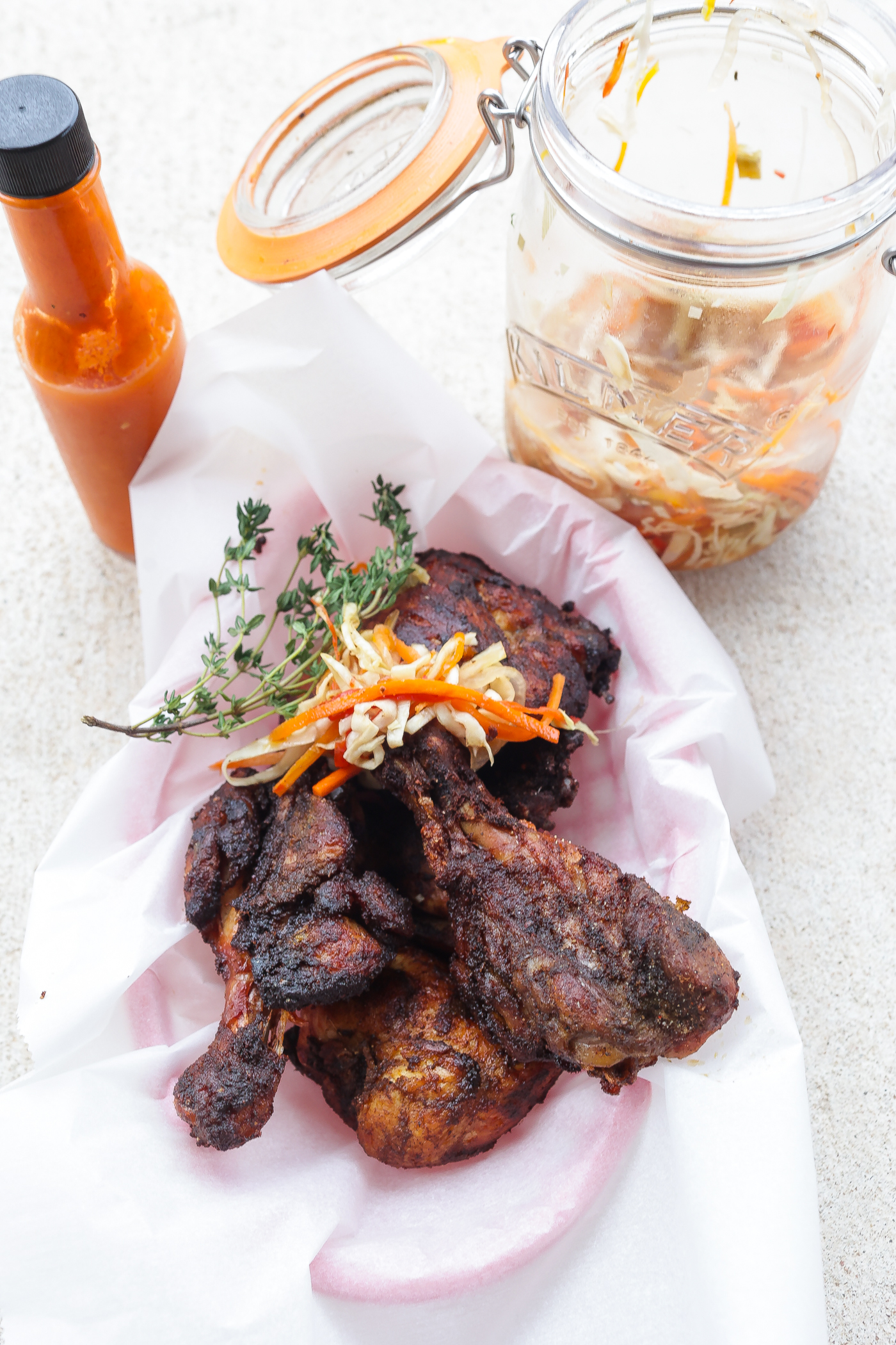 haitian fried chicken in a basket topped with pickled slaw