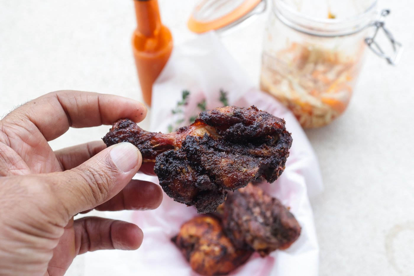 haitian fried chicken on a white plate topped with pickled slaw