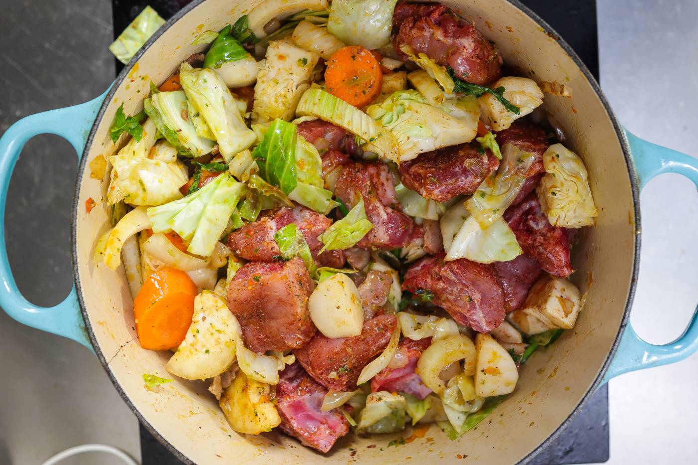 pork meat and vegetables cooking in a pot