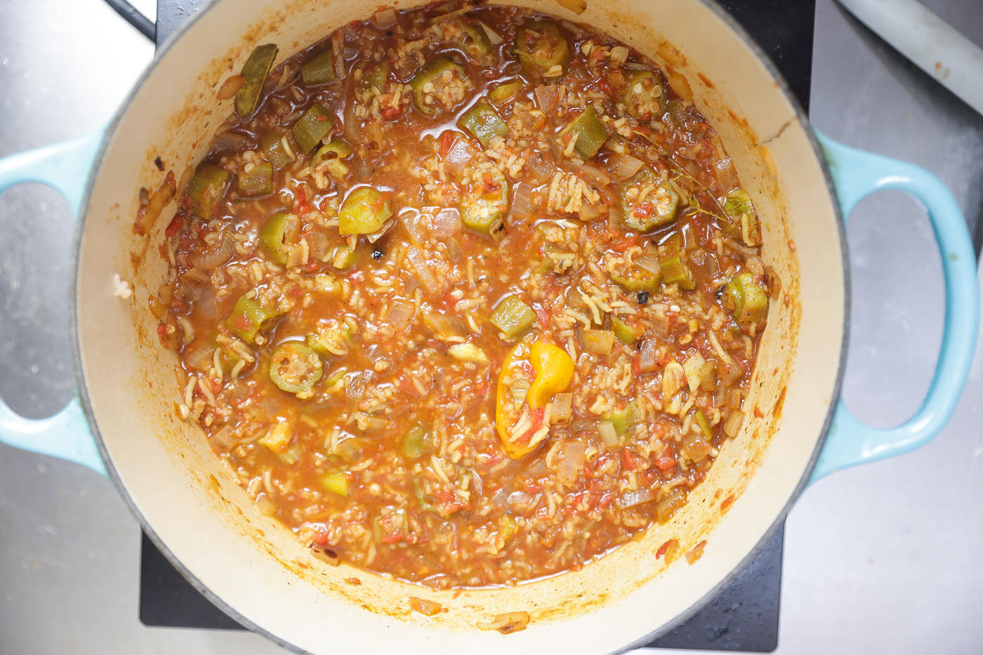 rice, tomatoes, and vegetables cooking in a pot