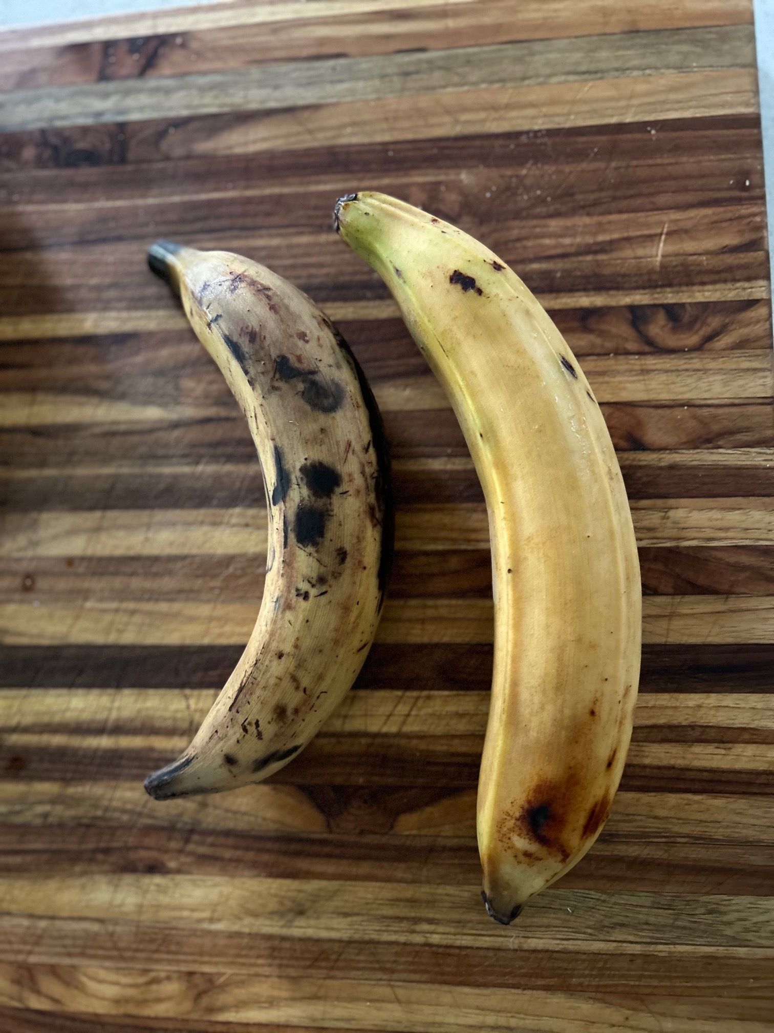 2 ripe plantains on a cutting block