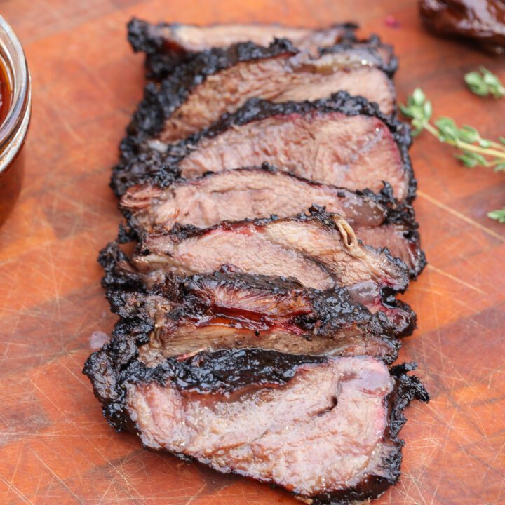 smoked beef cheeks sliced on a wooden cutting board