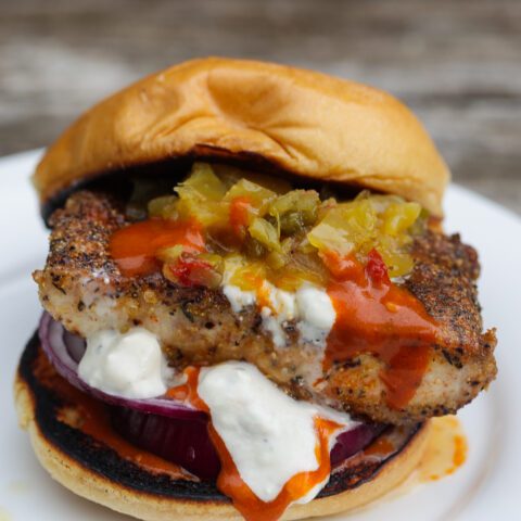 mahi mahi fish sandwich with orange and white sauces