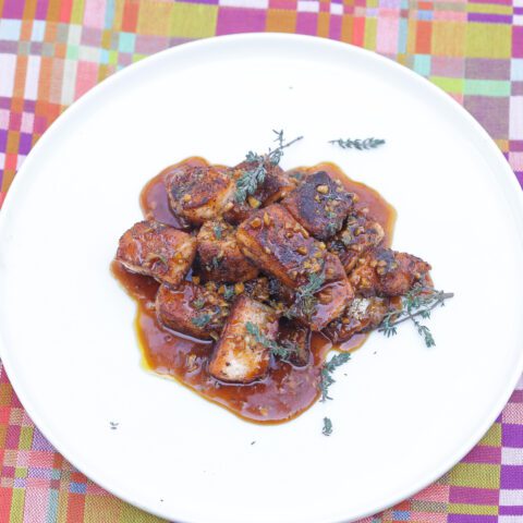 cubed pieces of salmon bites on a white plate topped with honey glaze