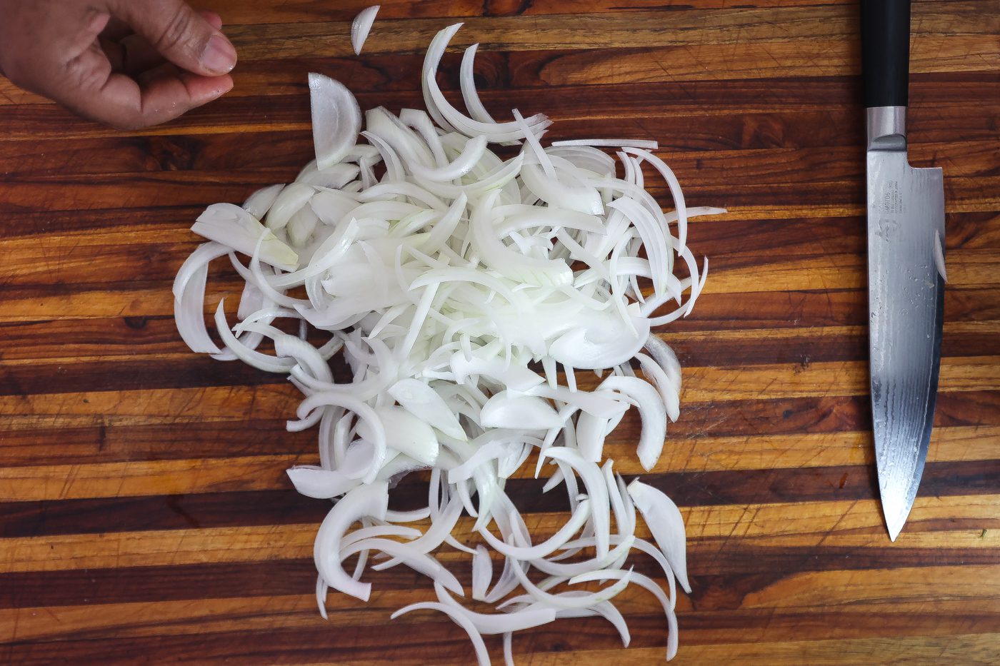 sliced white onions on cutting board