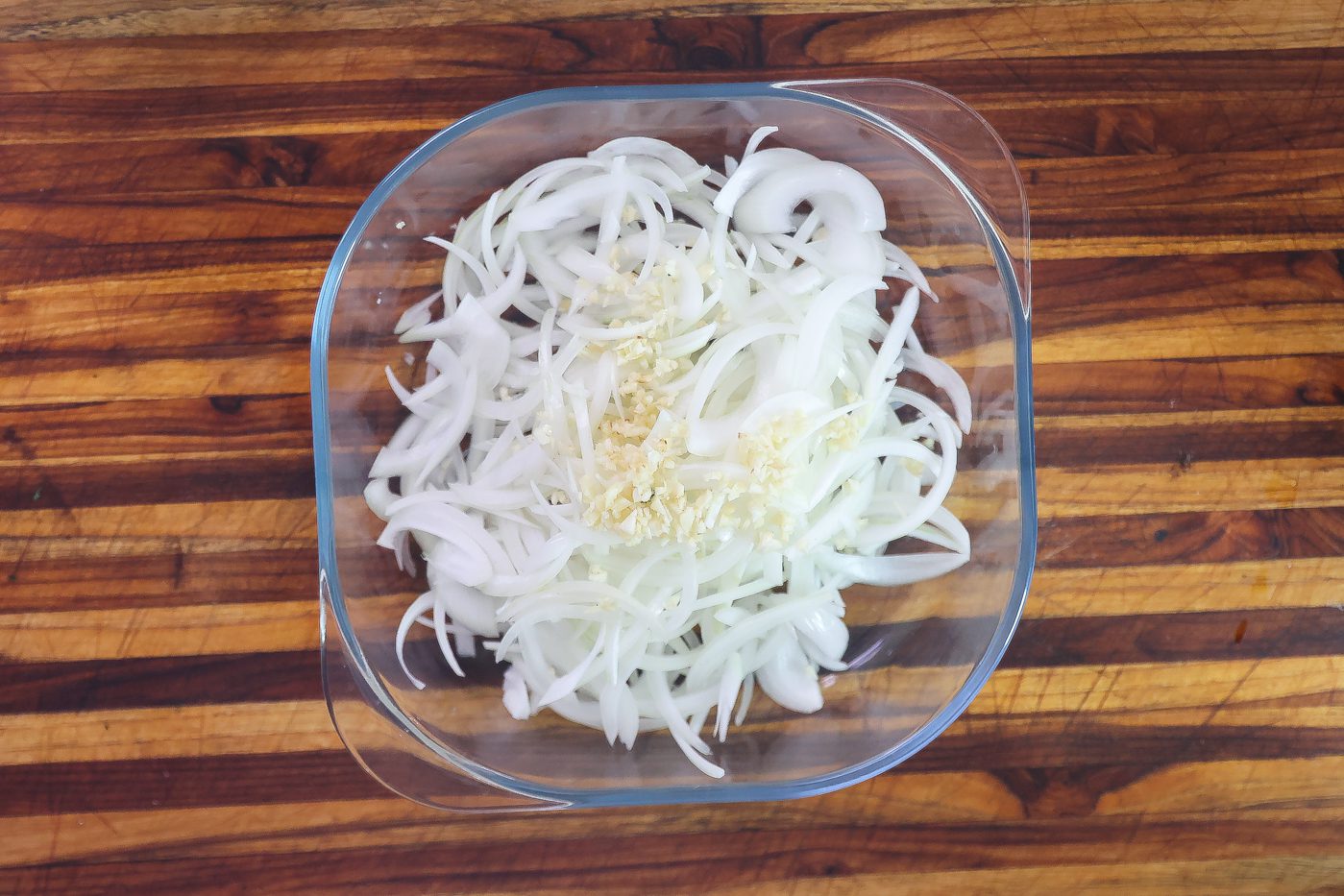 sliced white onions in bowl with mustard sauce