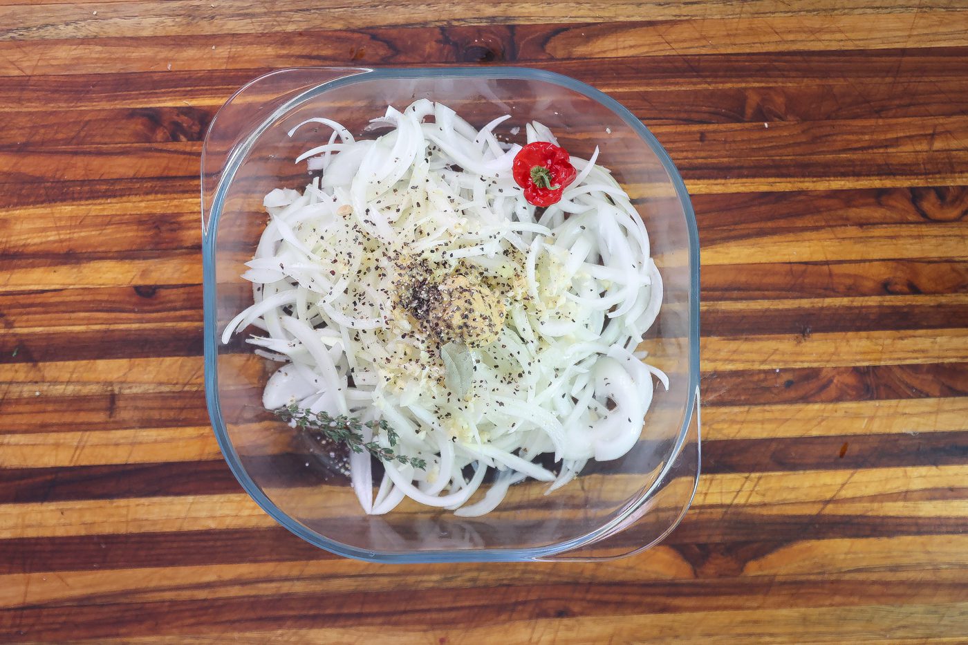 sliced onions in bowl with pepper and mustard sauce