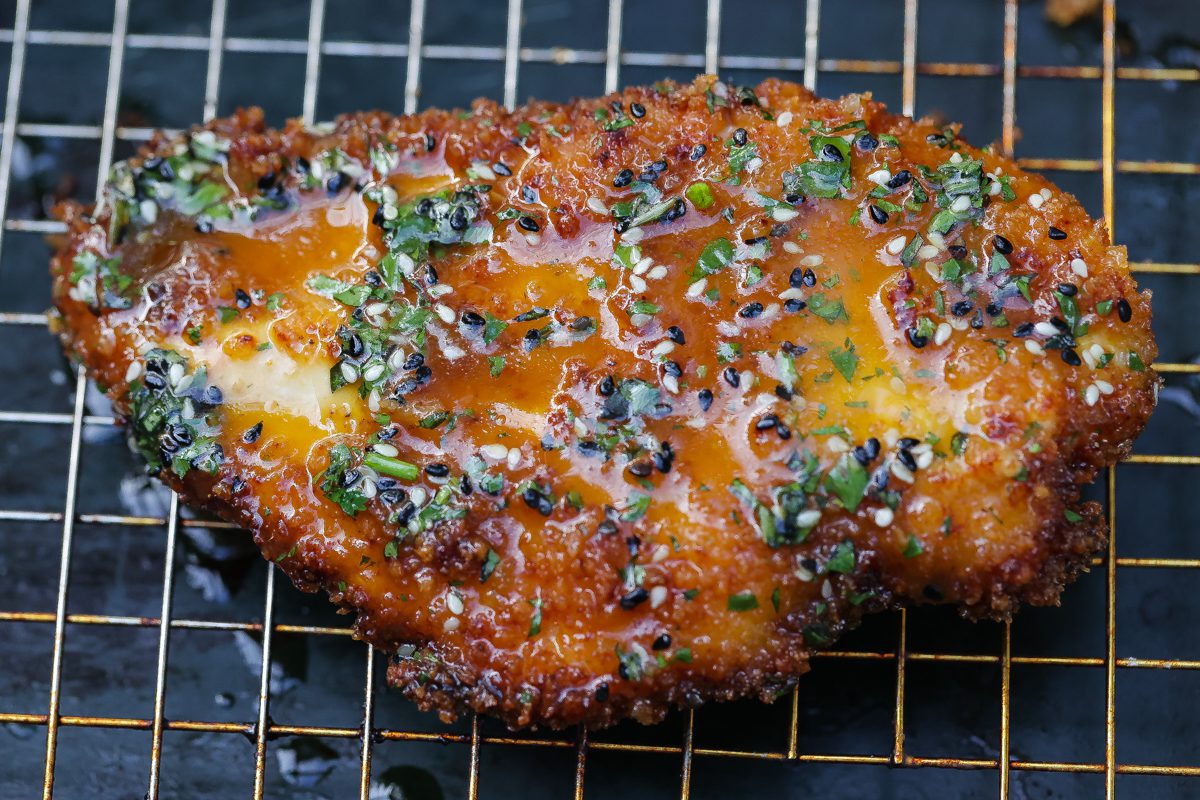 panko chicken breast with orange sauce on a tray