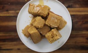 sweet potato cornbread squares stacked on a white plate