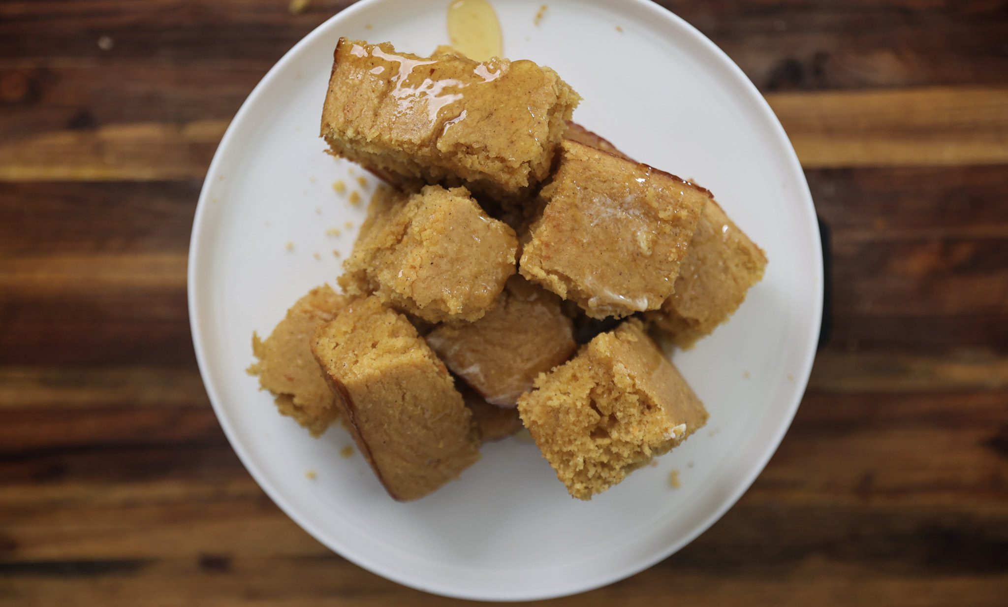 sweet potato cornbread squares stacked on a white plate