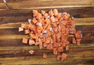 diced salmon pieces on cutting board