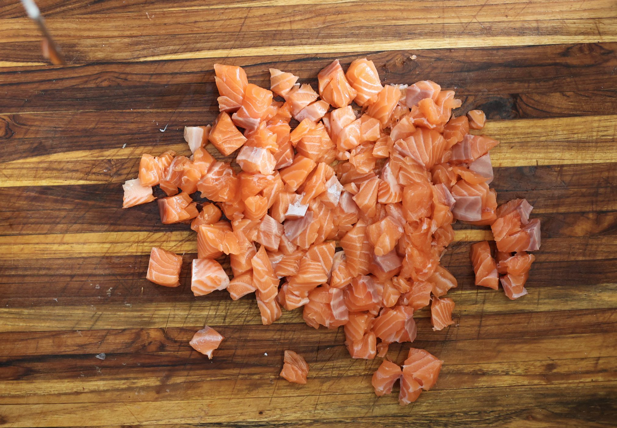 diced salmon pieces on cutting board