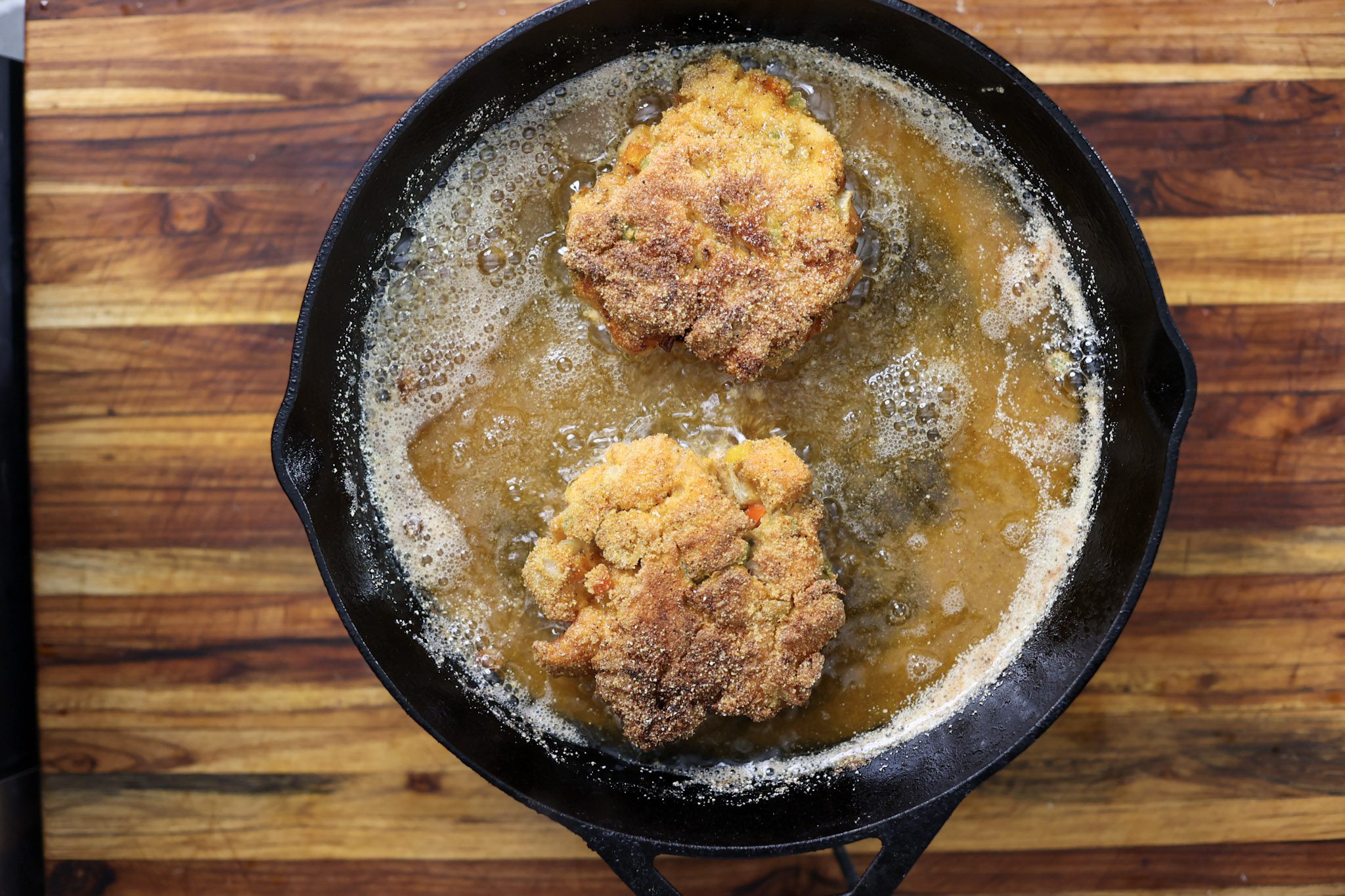 salmon croquette patties frying in skillet