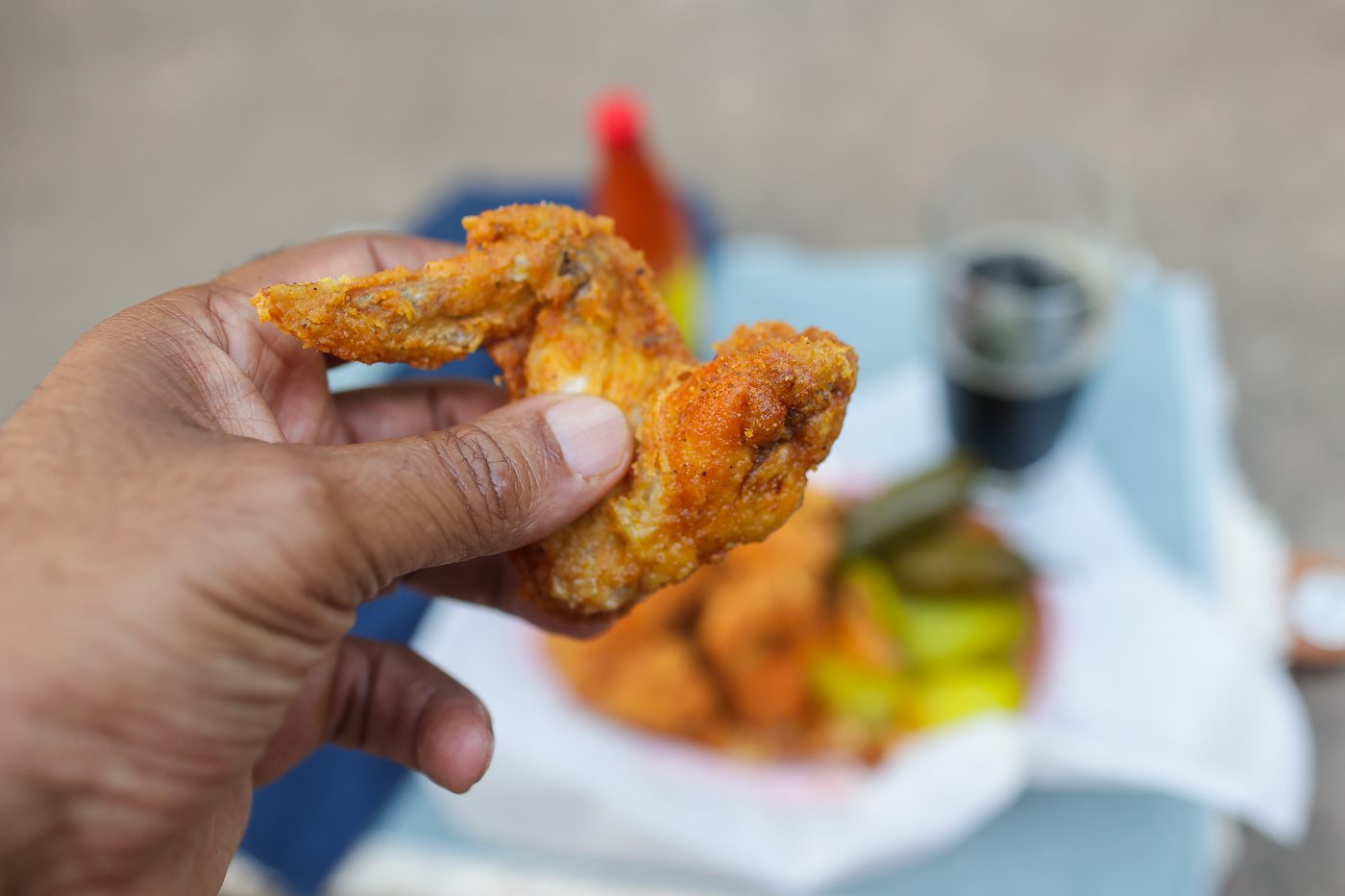fried chicken wing held in hand