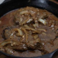 smothered steak and onion gravy in skillet