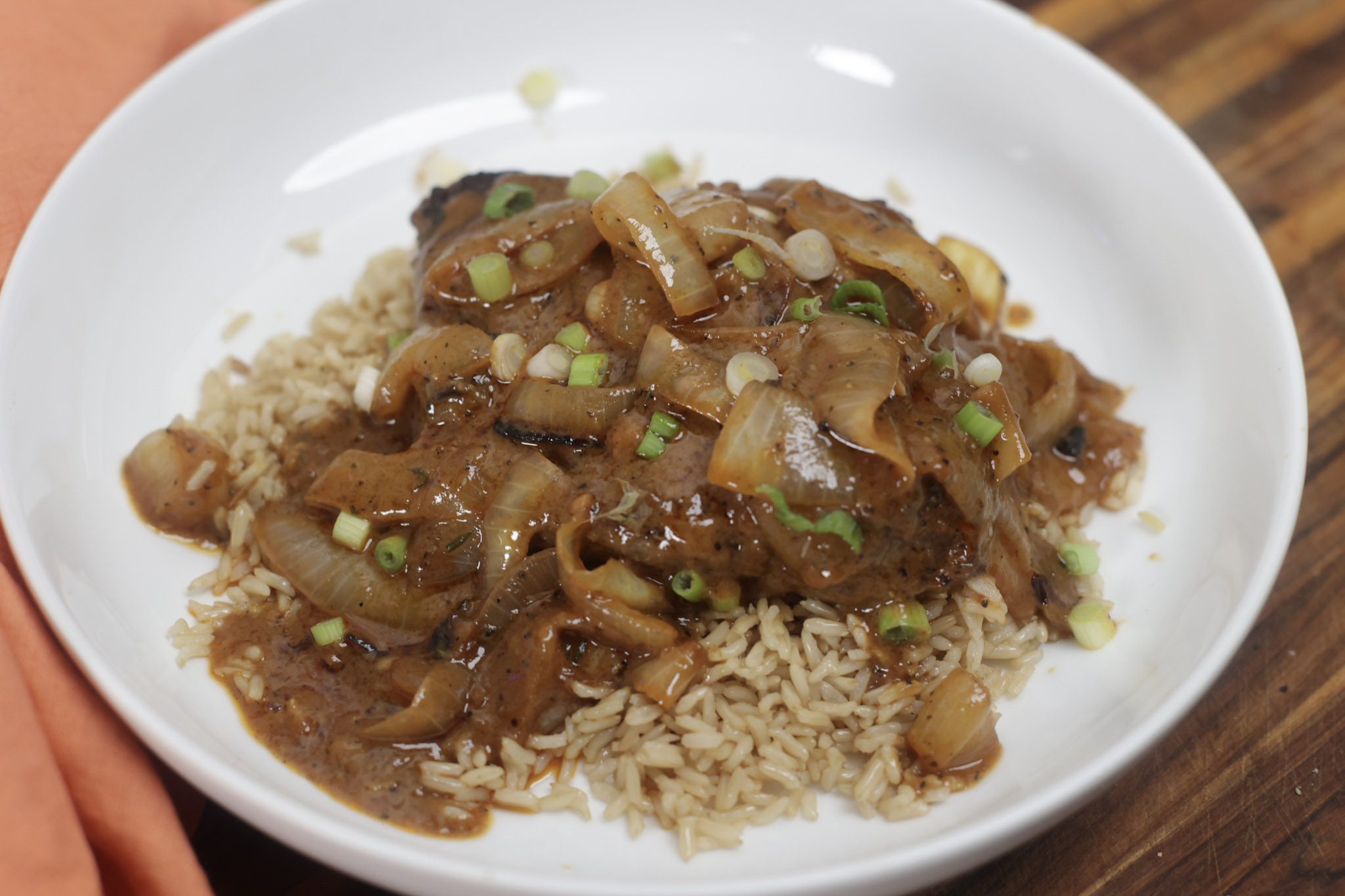 smothered steak and onion gravy with rice in white bowl