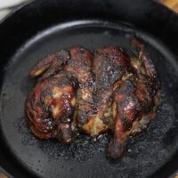 spatchcock baked jerk chicken in cast iron skillet