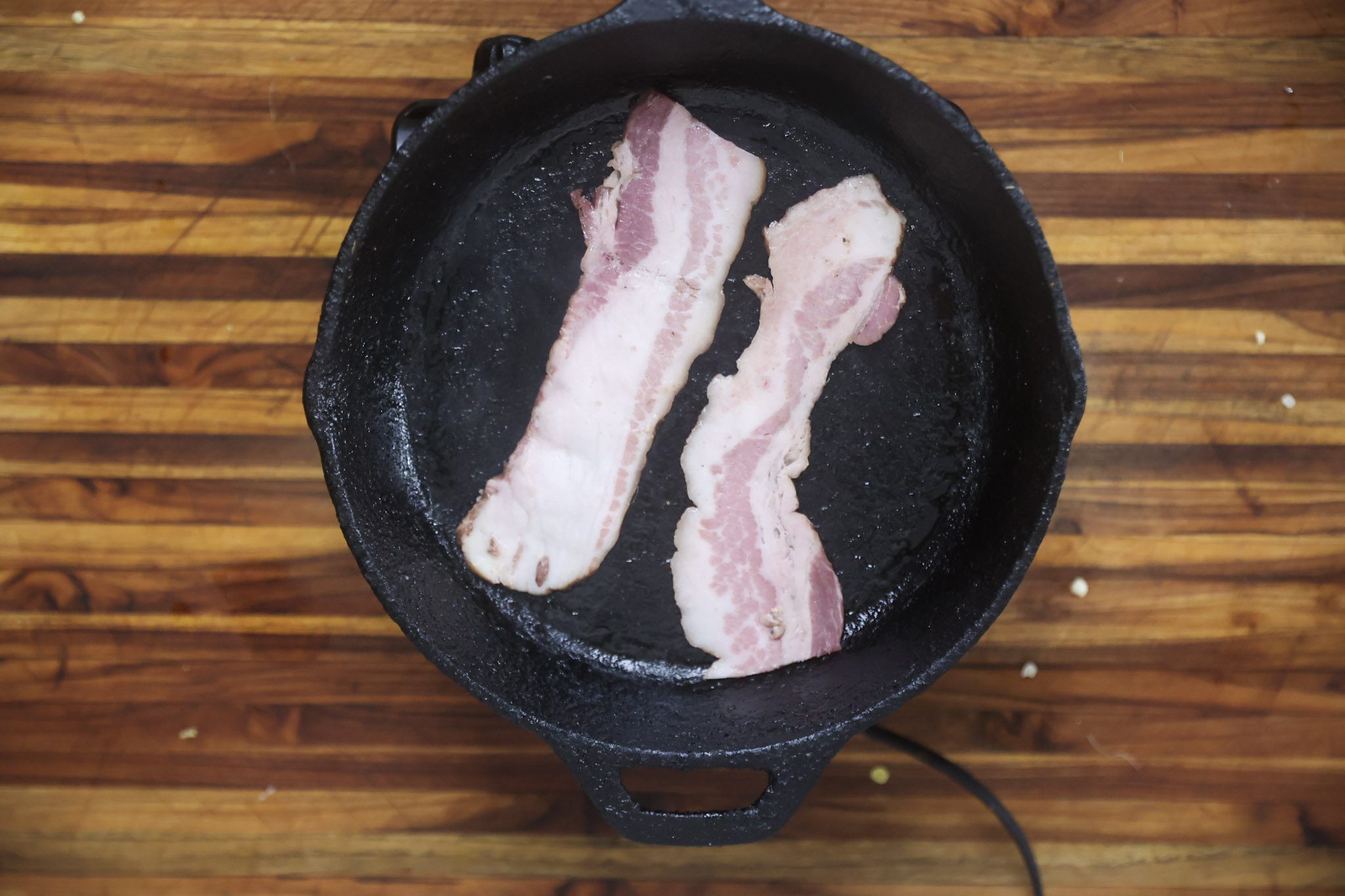 bacon frying in cast iron skillet
