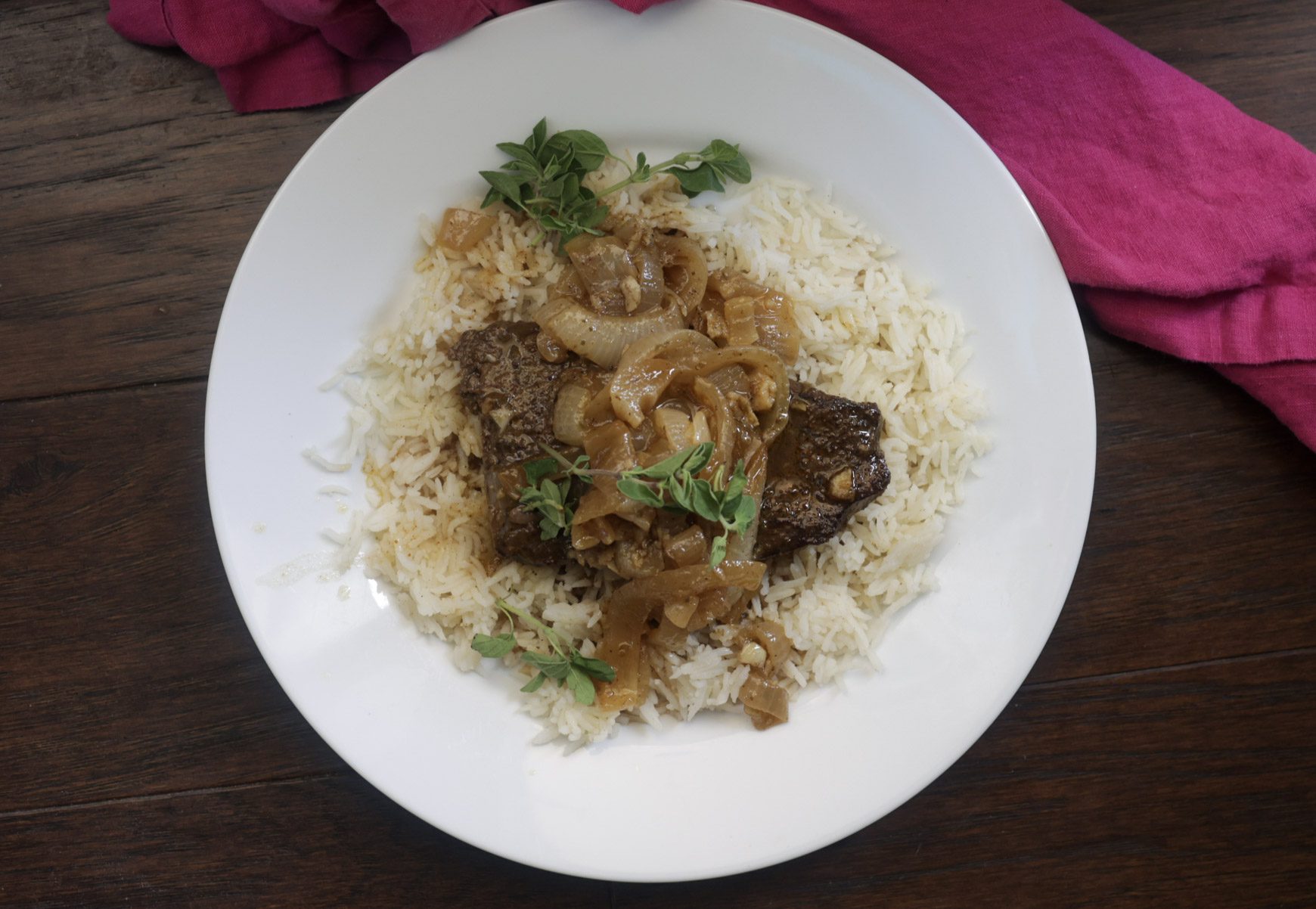 bistec encebollado with rice on plate