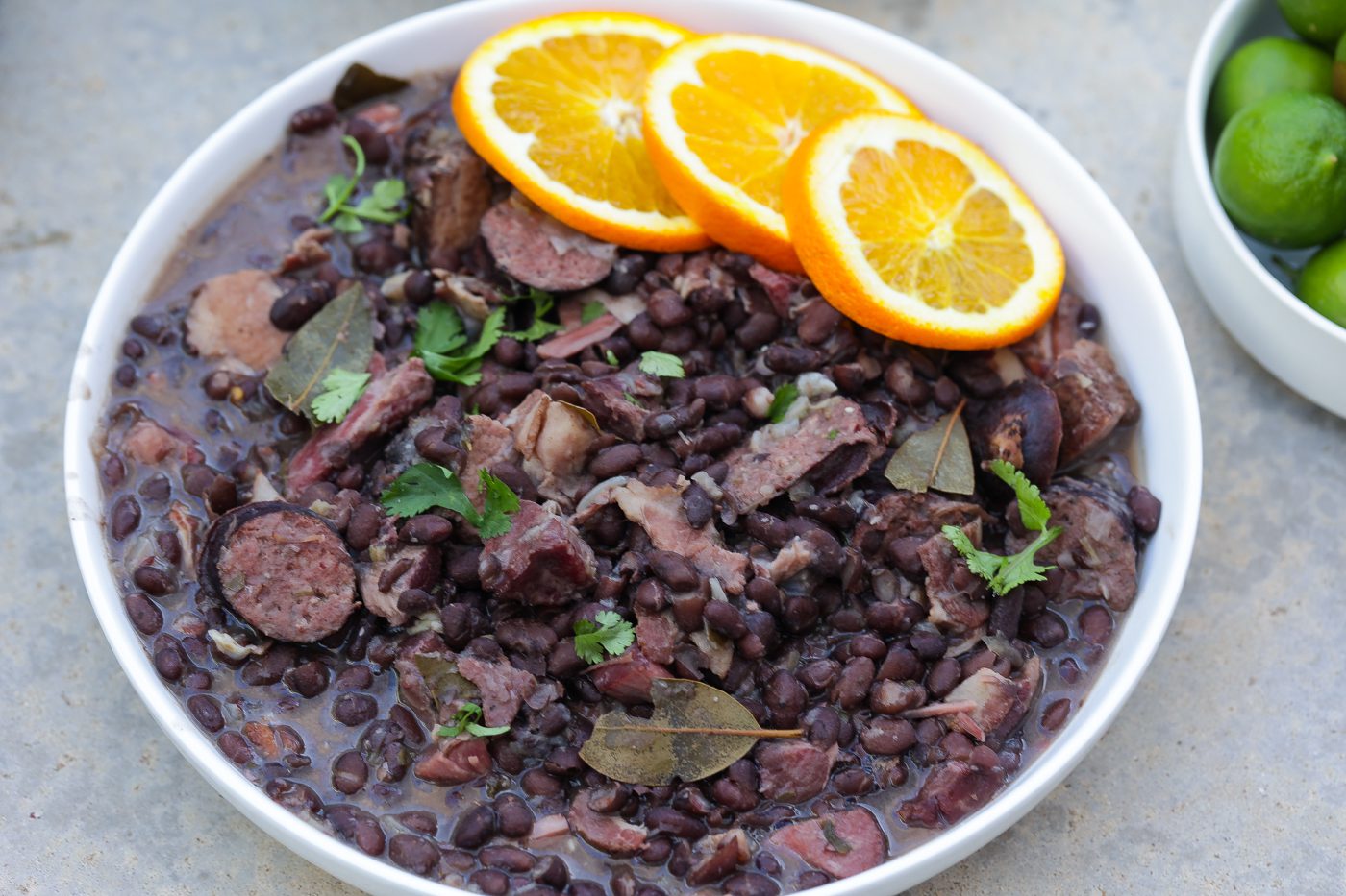 feijoada brazilian black bean and pork stew in a bowl topped with orange slices