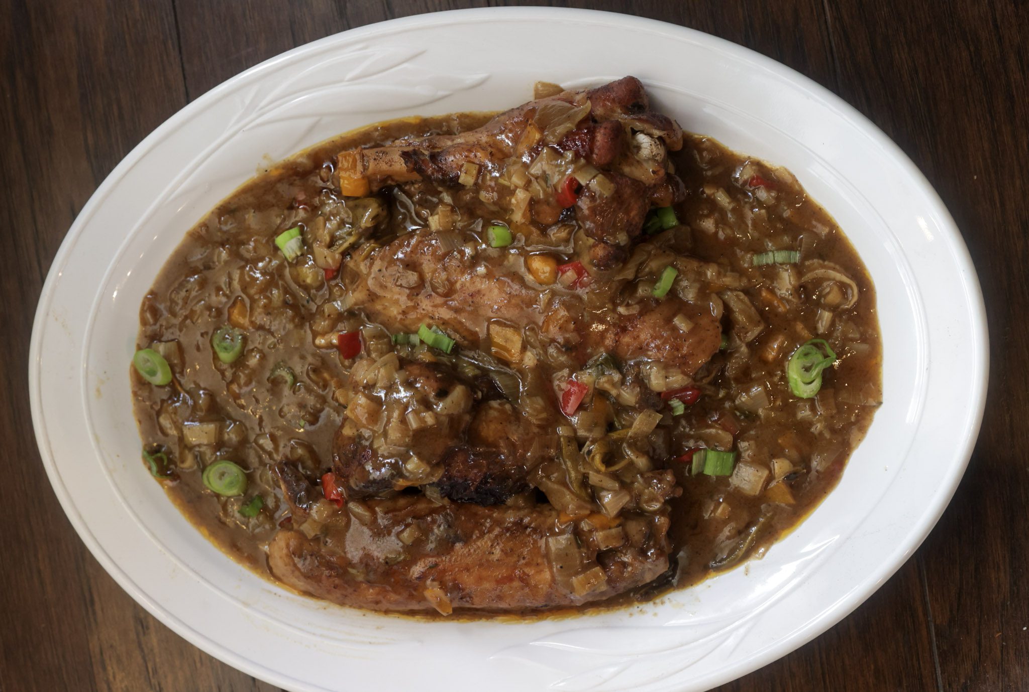 smothered turkey wings on white oval platter