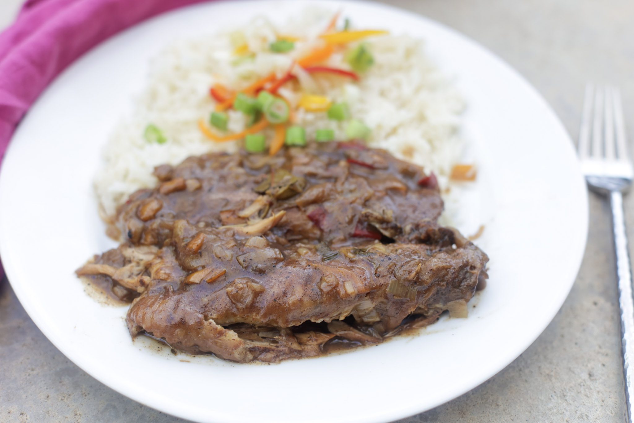 smothered turkey wings on plate with rice