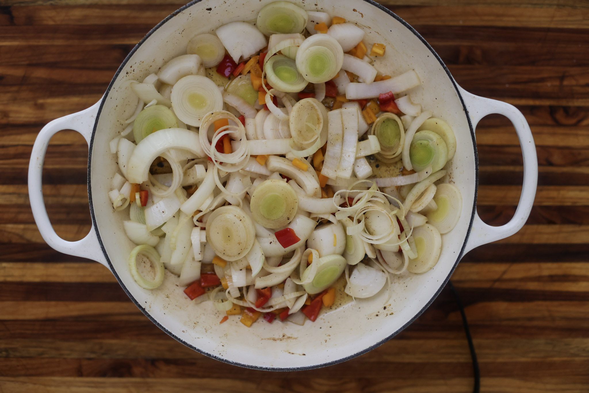 onions and peppers sauteing in pan