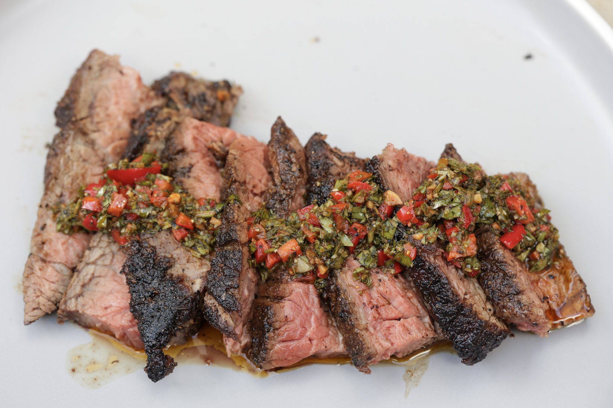 steak with chimichurri sauce on gray plate