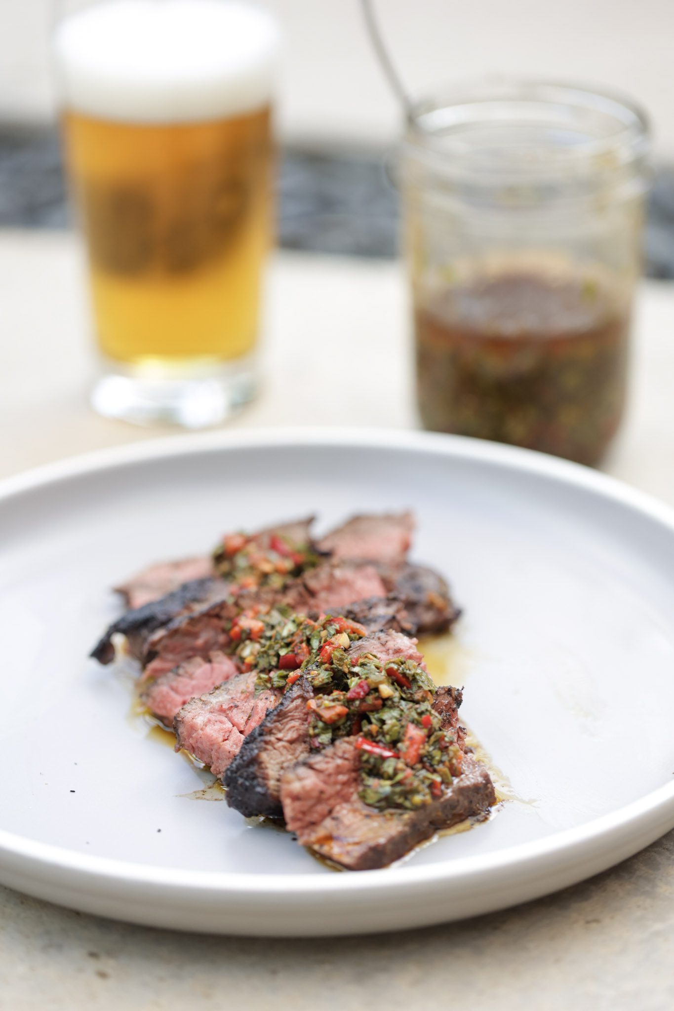 steak with chimichurri sauce on gray plate