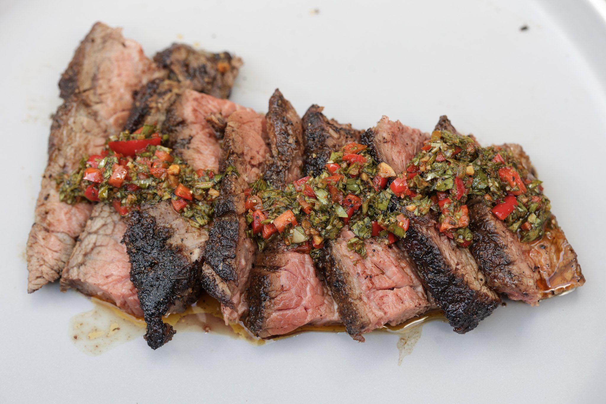 steak with chimichurri sauce on gray plate