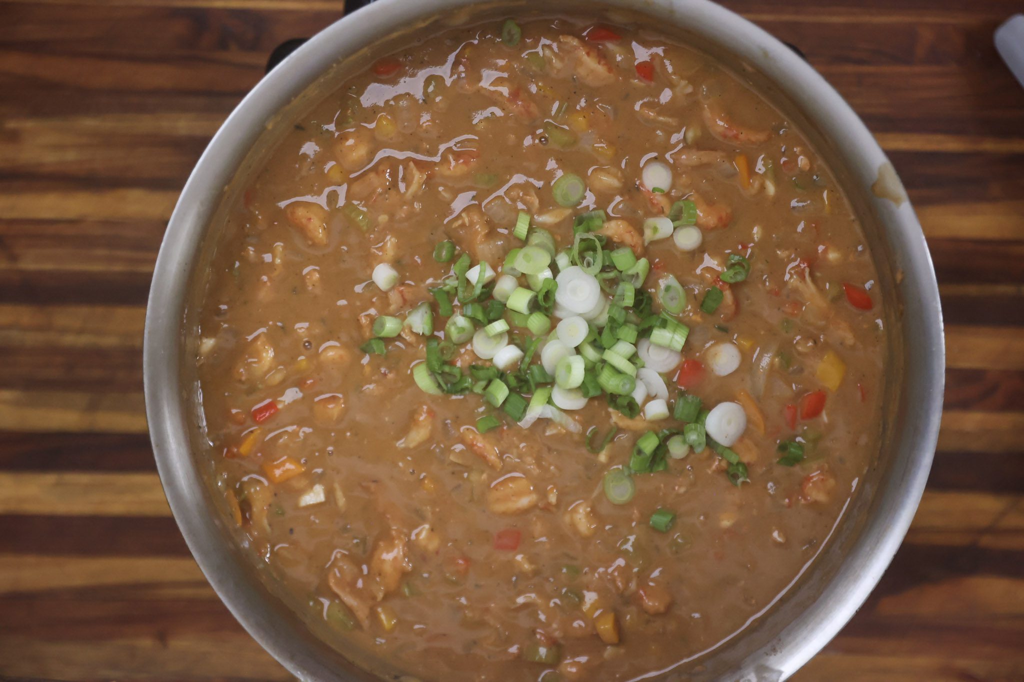 etouffee cooking in pan with green onions