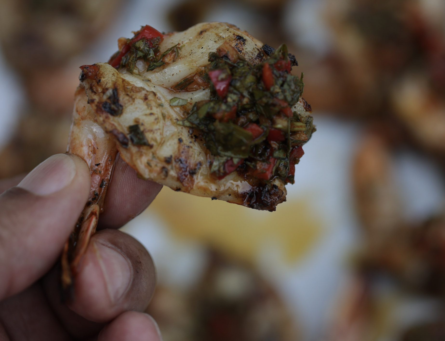 grilled chimichurri shrimp held in hand