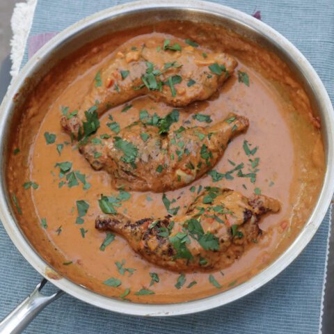 kuku paka African curry chicken in a skillet with coconut sauce