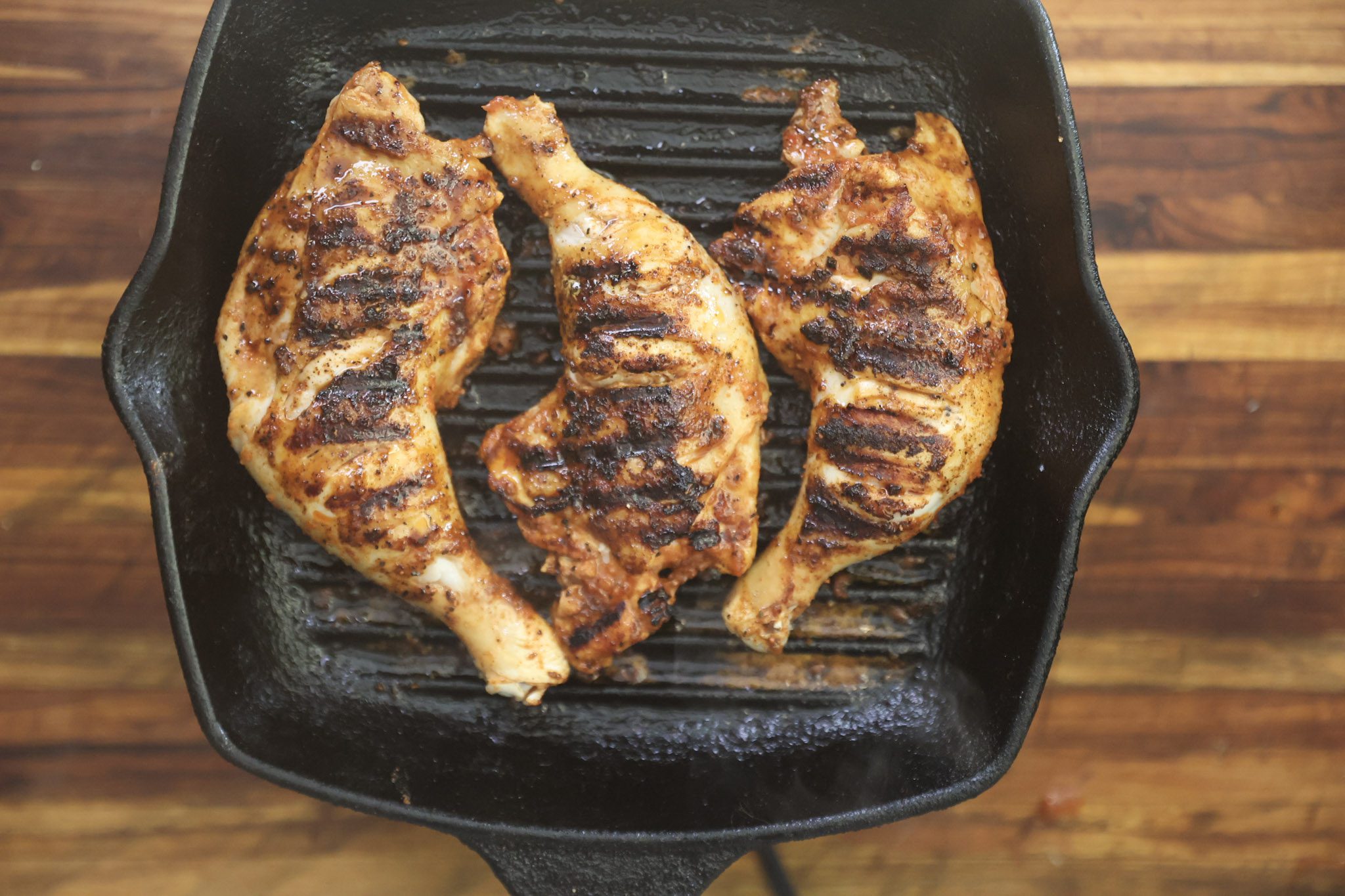kuku paka chicken cooking on cast iron grill
