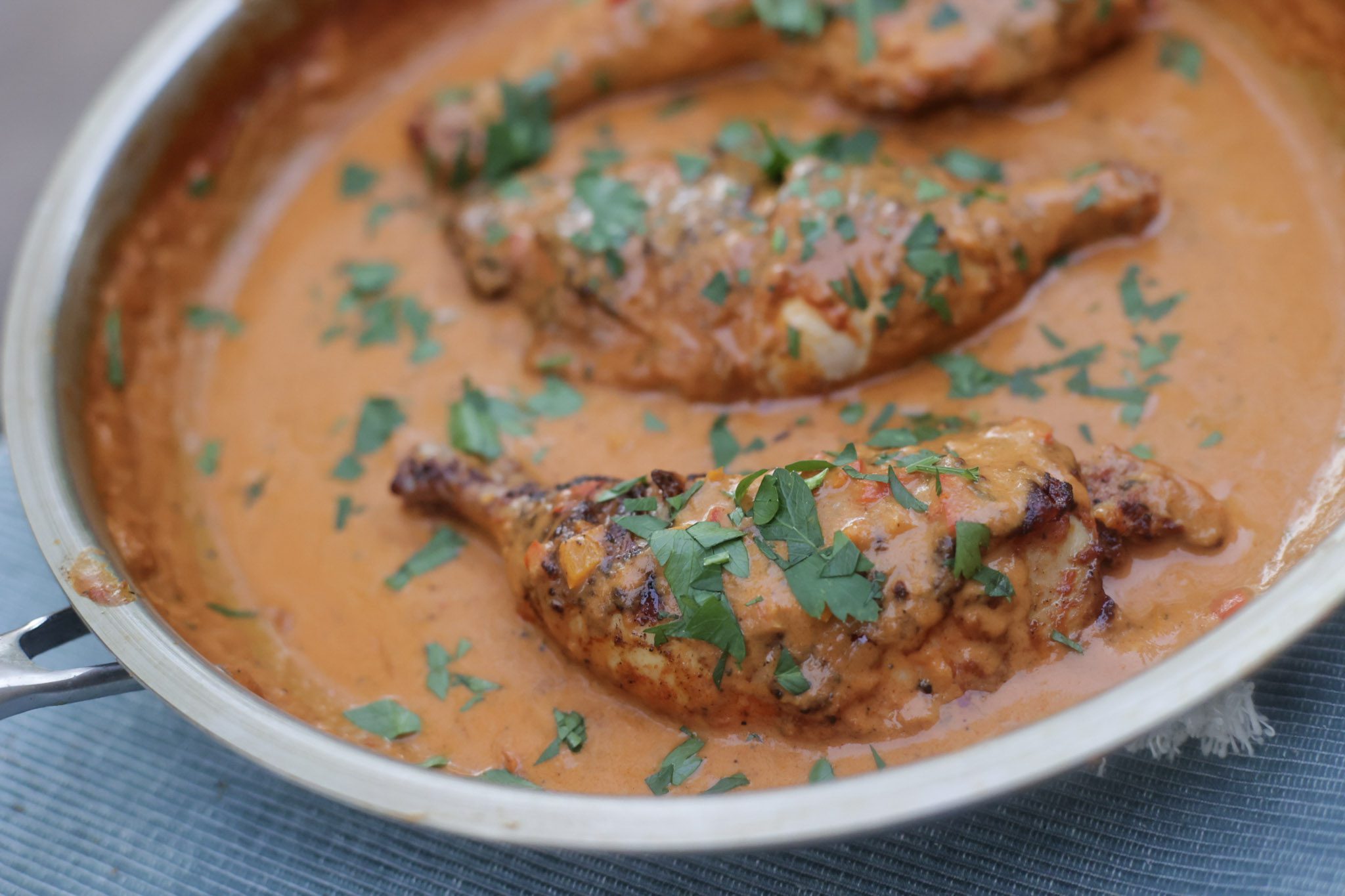 kuku paka African curry chicken in a skillet with coconut sauce