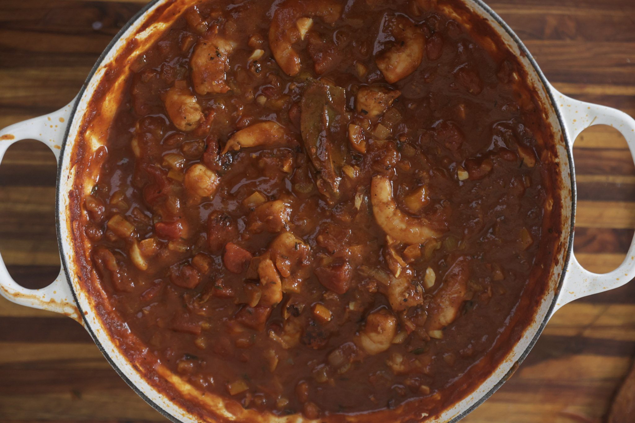 tomato base cooking down in skillet with shrimp