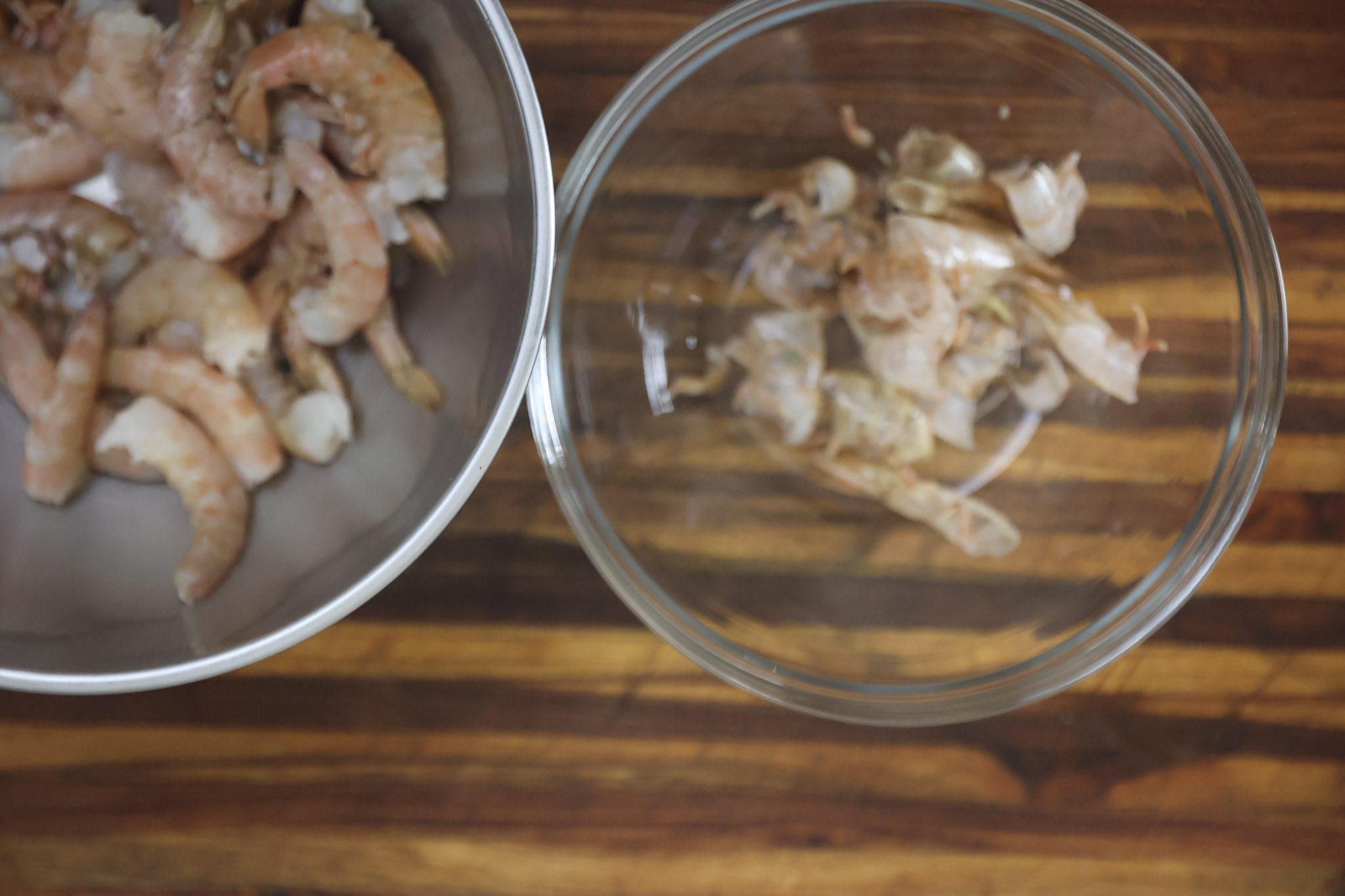 peeled shrimp and shells sitting in glass bowl