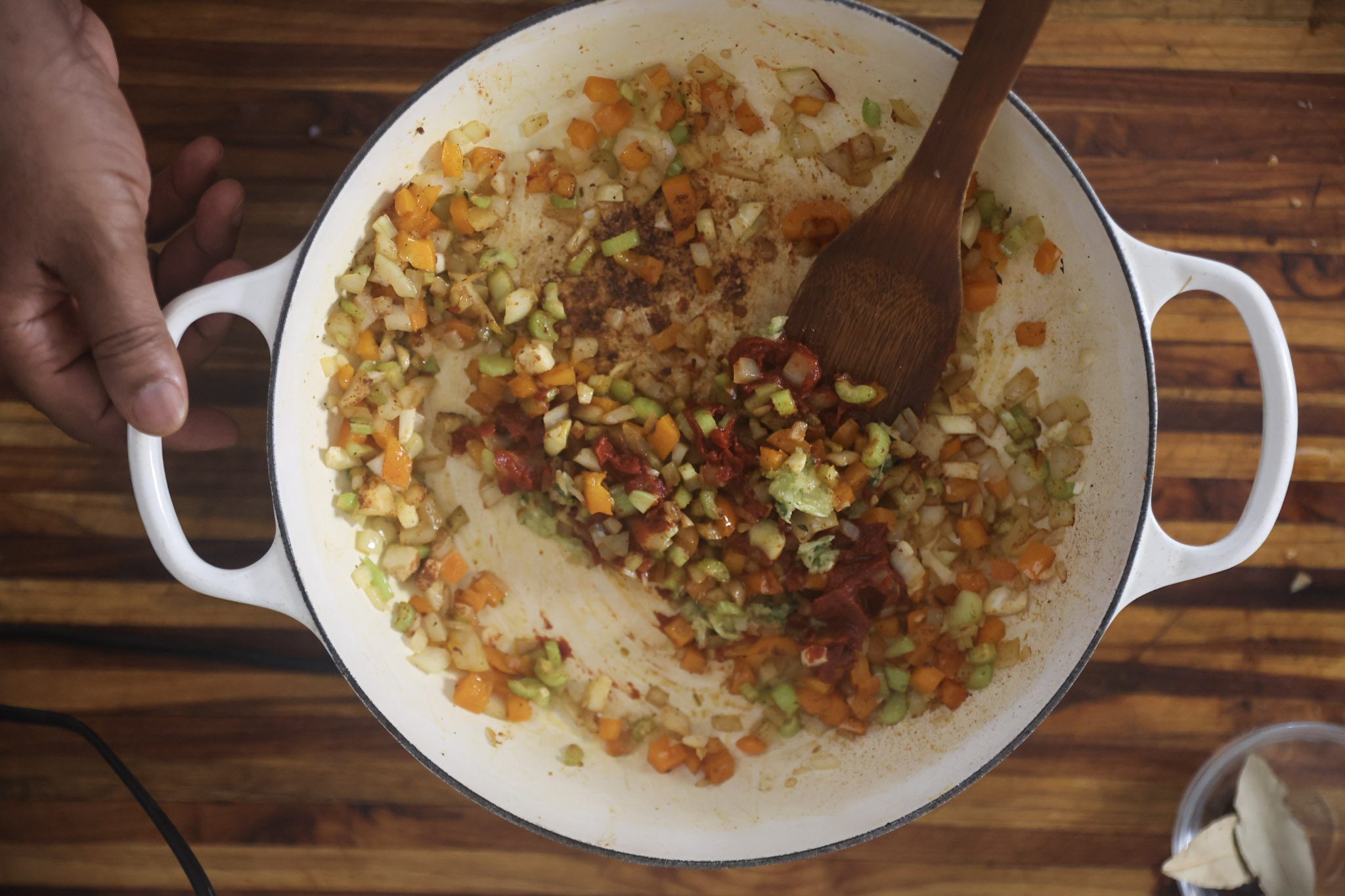 onions, peppers, celery, and tomato paste cooking in pan