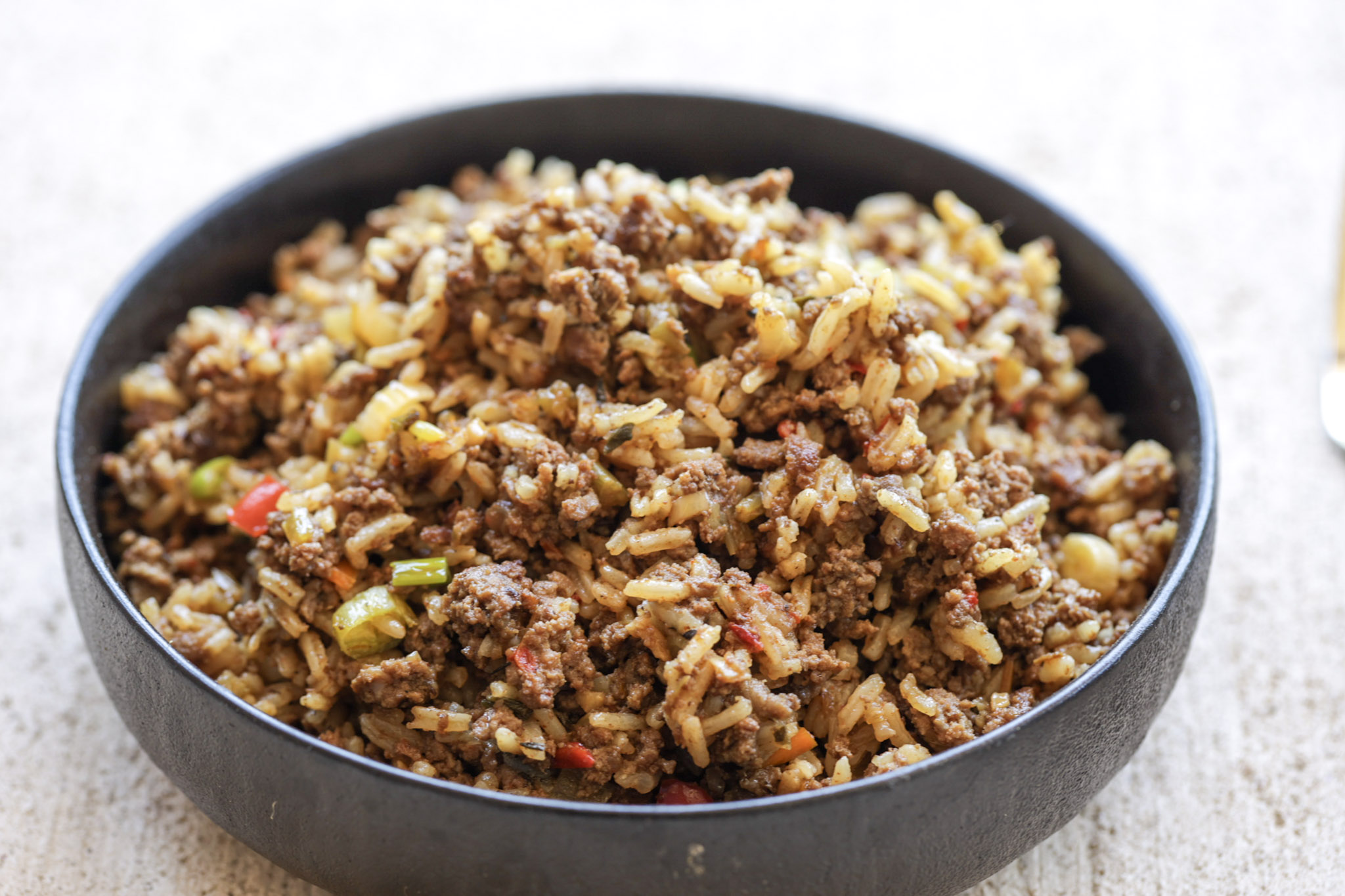 dirty rice in a black bowl