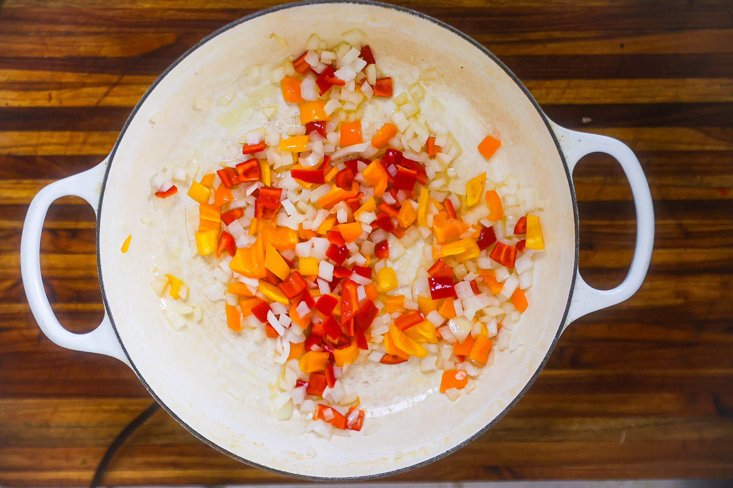 onions and peppers sauteing in pan